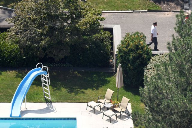 Governor Cuomo is seen, in an aerial photograph, walking on the grounds of the Executive Mansion with the pool seen to the left